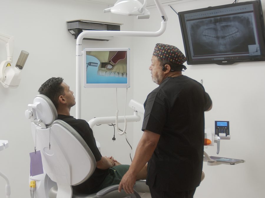 El Dr. Correa explica a un paciente su radiograf&iacute;a en la pantalla del gabinete
